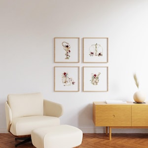 Puede incluir: Cuatro ilustraciones de acuarela enmarcadas de objetos dorados con acentos florales. Los objetos son una copa, una balanza, una jarra y una regadera. Las ilustraciones se colocan contra una pared blanca con un suelo de madera clara.