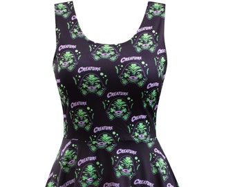 May include: A black skater dress with a repeating pattern of a green creature from the black lagoon with the word "Creature" printed in purple. The dress has a scoop neck and sleeveless design.