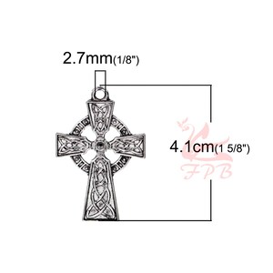 May include: Silver Celtic cross charm pendant with intricate knotwork design. Measures 1 5/8 inches in height and 1/8 inch in width.