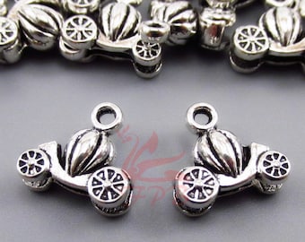 Op de afbeelding: Zilverkleurige metalen bedels in de vorm van een koets met wielen. De bedels hebben een lus aan de bovenkant om aan sieraden of andere knutselwerkjes te bevestigen.