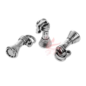 May include: Three silver-toned metal charms shaped like vintage flashlights. Each charm has a loop at the top for attaching to a necklace or bracelet.