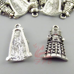 May include: Silver-toned metal charms in the shape of a Dalek, a fictional alien robot from the British science fiction television series Doctor Who. The charms are detailed with raised circles and lines, and have a loop at the top for attaching to jewelry or other crafts.