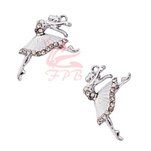 May include: Two silver ballerina charms with rhinestones. The ballerinas are in a dancing pose with their arms outstretched and one leg raised.