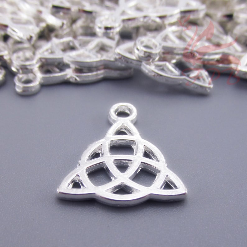 May include: Silver charm with a Celtic knot design. The knot is a triangle shape with a loop at the top for attaching to a necklace or bracelet.