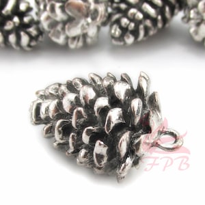 May include: Silver-toned metal pine cone charm with a loop for hanging. The pine cone is detailed with textured scales.