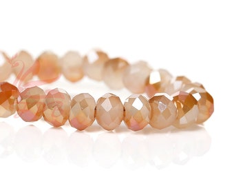 May include: A strand of faceted glass beads in a light peach color with a subtle iridescent sheen.