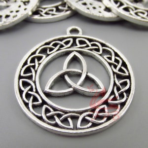 May include: Silver-colored Celtic knot pendant with a circular design. The pendant features a central triquetra knot within a ring, surrounded by intricate knotwork. A small loop is at the top for attaching to a chain or cord. The pendant is likely made of metal.