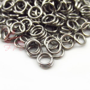 May include: A pile of silver jump rings, a type of metal ring used in jewellery making.