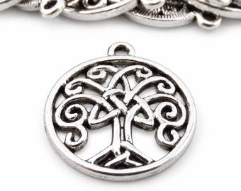 May include: A circular silver-toned metal charm featuring an openwork design of a tree with intricate, swirling branches and roots enclosed within a round frame. The charm includes a small loop at the top for attachment to jewelry.