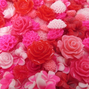 Peut inclure: Gros plan sur une collection de diverses fleurs artificielles dans les tons de rouge, rose et blanc. L'assortiment comprend des roses, des dahlias et d'autres motifs floraux, créant un affichage vibrant et coloré. Les fleurs sont en matière brillante.