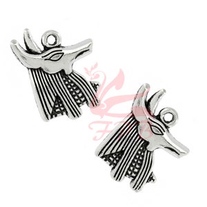 May include: Two silver charm pendants in the shape of an Anubis head. The pendants have a detailed design with a textured surface.