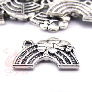 May include: Silver charm featuring a rainbow with a cloud shaped like a four-leaf clover. The charm has a loop for attaching to a necklace or bracelet.