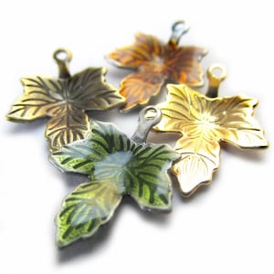 May include: Four metal leaf charms in different colors: gold, green, brown, and silver. Each leaf has a small loop at the top for attaching to jewelry or other crafts.