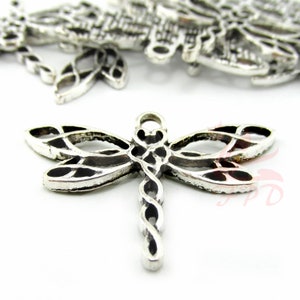 May include: Silver-toned metal dragonfly charm with intricate details. The dragonfly has a twisted body and delicate wings.