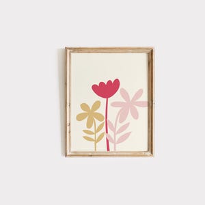 May include: A framed print with a minimalist design featuring a pink, red, and yellow flower arrangement on a white background.