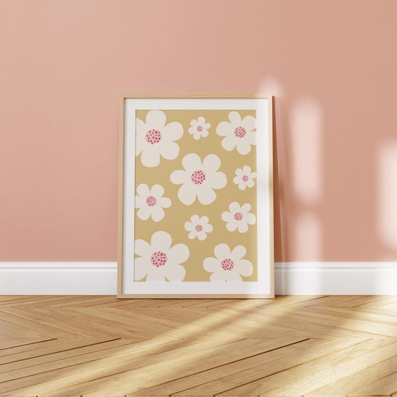 May include: A framed print with a pattern of white flowers with pink centers on a light brown background.