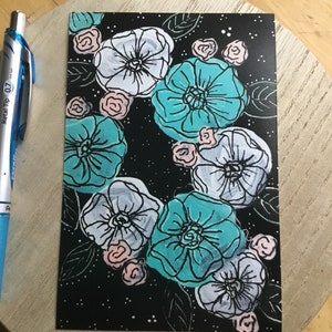 May include: A black background with a floral pattern featuring white, teal, and pink flowers. The flowers are outlined in black and have a whimsical, hand-drawn style.