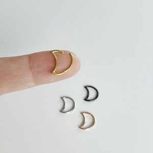 May include: Four crescent moon shaped hoop earrings in gold, silver, rose gold, and black.