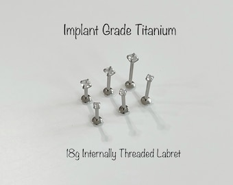 May include: Six 18 gauge internally threaded titanium labrets with clear cubic zirconia gems. Implant grade titanium.