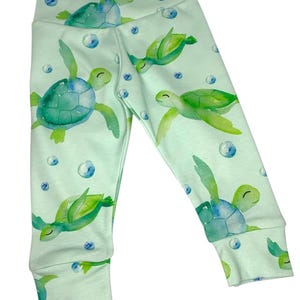 May include: Mint green leggings with a watercolor print of sea turtles and bubbles.