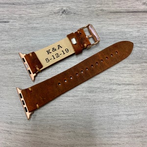 Peut inclure: Un bracelet de montre Apple en cuir marron avec une inscription personnalis&eacute;e qui dit "K&A 5-12-19".