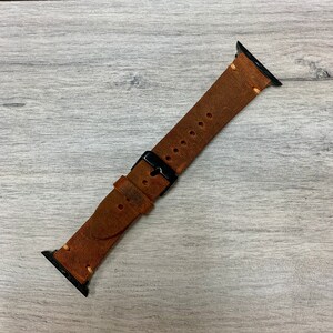 Peut inclure: Un bracelet de montre en cuir marron avec des accessoires en m&eacute;tal noir. Le bracelet a un aspect vieilli et est con&ccedil;u pour une montre connect&eacute;e.