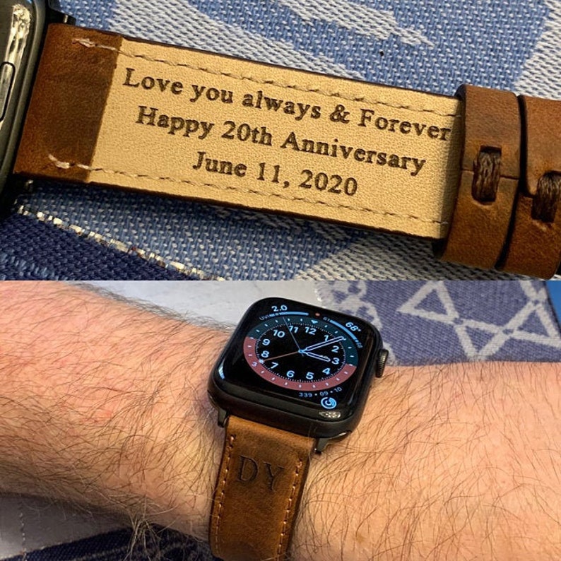 Puede incluir: Una correa de reloj de cuero marr&oacute;n con la inscripci&oacute;n "Love you always & Forever Happy 20th Anniversary June 11, 2020". La correa se muestra en una mu&ntilde;eca con una esfera de Apple Watch negra.