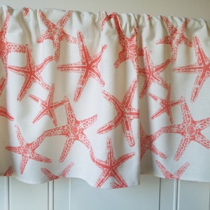 May include: A white valance with a coral starfish pattern. The valance is gathered at the top and has a scalloped bottom edge.