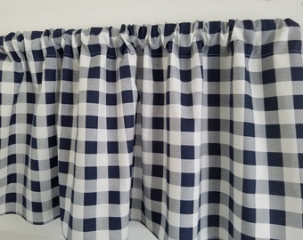 May include: A navy blue and white gingham valance with a ruffled bottom edge.