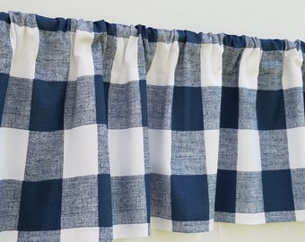May include: A navy blue and white buffalo check valance with a ruffled edge. The valance is made of a textured fabric.