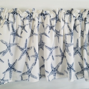 May include: White valance with a blue starfish pattern. The valance has a ruffled top and a straight bottom.