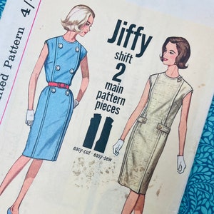 Op de afbeelding: Een vintage Simplicity Jiffy shift-jurk naaipatroon envelop met illustraties van twee mouwloze jurken, een blauwe met een rode riem en een beige, met tekst waaronder Size 16, Bust 36 en 2 main pattern pieces voor easy-cut easy-sew.