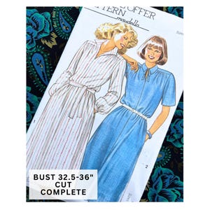 Könnte beinhalten: Ein Maudella Schnittmusterumschlag mit Illustrationen von zwei Kleiderstilen. Ein Kleid hat lange Ärmel und ein Streifenmuster, das andere ist ein blaues Kleid mit kurzen Ärmeln und Bindekragen. Der Text lautet BUST 32.5-36" CUT COMPLETE.