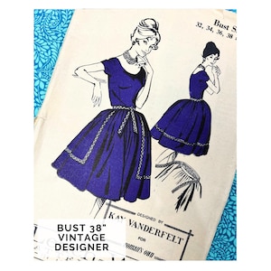 Op de afbeelding: Vintage naaipatroon ontworpen door Kay Vanderfelt. De illustratie toont een vrouw in een donkerblauwe jurk met korte mouwen, een getailleerde taille en een uitlopende rok. Het patroon is voor een borstomvang van 96.5 cm.
