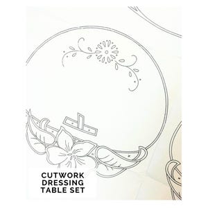 Puede incluir: Un juego de tocador de calado blanco con un diseño floral y de hojas. El juego presenta un patrón circular con un motivo de flores y hojas, y el texto "CUTWORK DRESSING TABLE SET" se muestra en la parte inferior de la imagen.