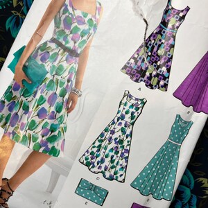 Pode incluir: Um envelope de molde de costura para um vestido sem mangas com decote quadrado e saia evasê, apresentando ilustrações de vários designs de vestidos com padrões florais, geométricos e de bolinhas, juntamente com designs de bolsas combinando rotulados de A a E.