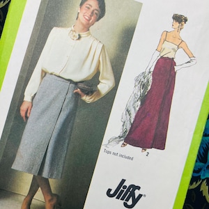 May include: A sewing pattern envelope labelled 9113 and Jiffy featuring illustrations of two skirt styles. One image shows a grey knee-length skirt with a front overlap, and the other shows a long, dark red skirt. The text reads Tops not included.
