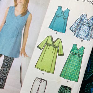 Op de afbeelding: Een naaipatroon-envelop voor Simplicity easy-to-sew kledingstukken. De voorzijde toont een blauwe mouwloze top, een lichtgroene jurk, een blauwe bloemrijke top, een groen geruite jurk en twee broeken. De tekst bevat Simplicity en easy-to-sew.