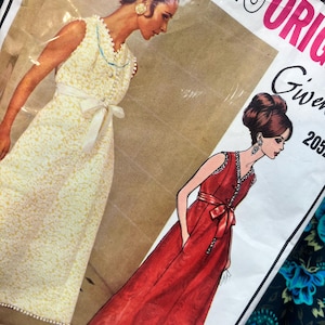 May include: A sewing pattern envelope featuring illustrations of two sleeveless floor-length dresses. One dress is yellow with a white waist tie, and the other is red with a matching waist tie and pockets. The text reads PARIS ORIGINALS Givenchy 2052.