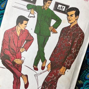 May include: A vintage sewing pattern envelope featuring illustrations of three pajama sets. One set is red with white vertical stripes, one is solid green with a brown collar, and one is a dark red and black paisley print. The text reads Style 17.
