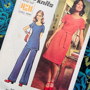 May include: A Simplicity Jiffyknits sewing pattern envelope for size 20, bust 42. The front features illustrations of a blue short-sleeved top with matching flared trousers and a red short-sleeved dress with a tie waist. Text includes Jiffyknits, easy cut, easy sew, and Sized for Stretch Knits Only.