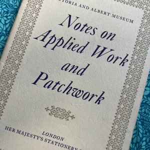 Pode incluir: Uma capa de livro vintage intitulada "Notes on Applied Work and Patchwork" do Victoria and Albert Museum. A capa é branca suja com desenhos de bordas cinza ornamentados e texto em azul escuro. Publicado pela Her Majesty's Stationery Office, Londres.