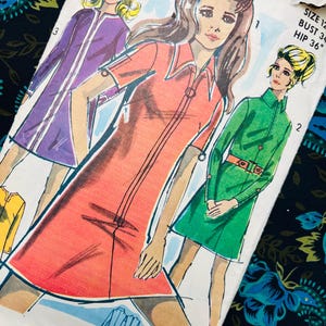 May include: Vintage sewing pattern featuring illustrations of women's dresses in shades of red, purple, and green. The pattern includes sizing information: Bust 34 inches, Hip 36 inches. The brand name "Madella" is visible at the top.