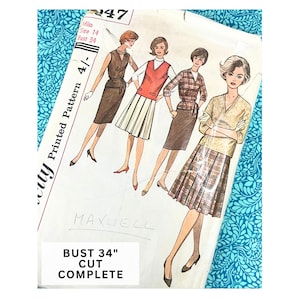 May include: A vintage sewing pattern envelope marked 247, Miss Size 14, Bust 34. The front features illustrations of four outfits, including a sleeveless dress, a sweater vest with a pleated skirt, a plaid blouse with a skirt, and a patterned top with a pleated skirt.