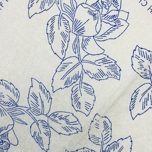 May include: A light beige paper surface featuring a repeating blue ink line drawing of rose blossoms and leaves. The text CLARK'S and FT N. 9 are partially visible in the upper corners, printed in a simple blue sans-serif font.