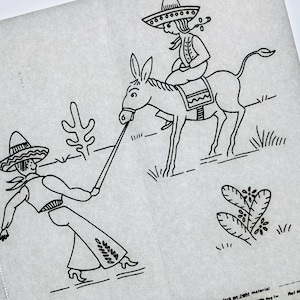May include: A white iron-on transfer sheet featuring a black line drawing of a person in a sombrero leading a donkey with a rider in a sombrero. The design includes two cacti and the text Ref No. K19559 printed in the bottom right corner.