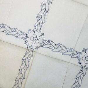 May include: A white paper pattern featuring a dark blue ink design of repeating floral motifs and interconnected leaf garlands. The pattern is printed on multiple joined sheets of paper, displaying a continuous decorative border layout.