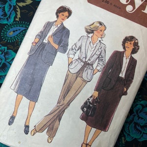 Peut inclure: Une pochette de patron de couture vintage intitulée Style présentant des illustrations de trois tenues : un tailleur jupe gris, un blazer clair avec un pantalon beige et un tailleur jupe marron foncé. Le texte indique Size 8 et Bust 80 cm.