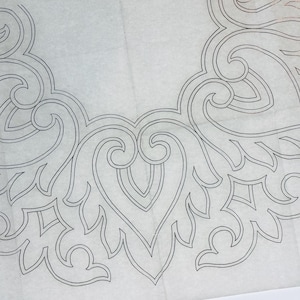 May include: A white fabric sheet featuring a black line drawing of a symmetrical, repeating scrollwork pattern. The design consists of curved, leaf-like shapes and interconnected swirls arranged in a circular formation across the surface.
