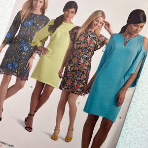 May include: A Simplicity sewing pattern envelope featuring four dress variations: a blue floral embroidered dress, a solid lime green dress, a black floral print dress with flutter sleeves, and a solid turquoise cold-shoulder dress with crisscross neck detail.